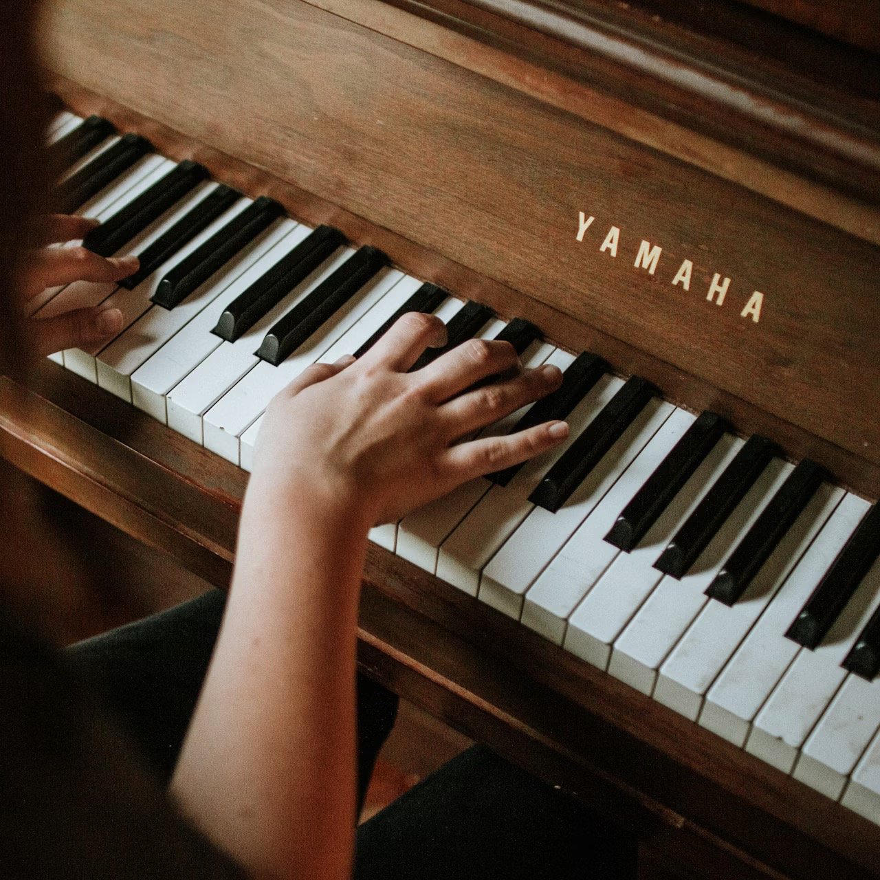 Photo of someone's hands playing a piano